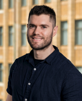 Smiling person in front of building background.
